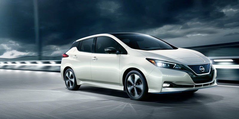 A white 2022 Nissan LEAF driving down the highway