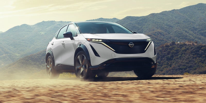 Stunning Exterior view of White Nissan Ariya parked on sandy surface